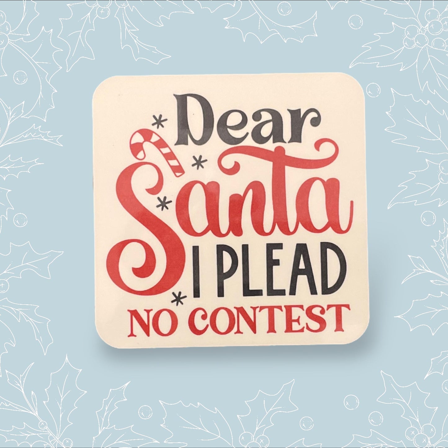 Square coaster with ‘Dear Santa, I plead no contest’ in black and red with festive embellishments