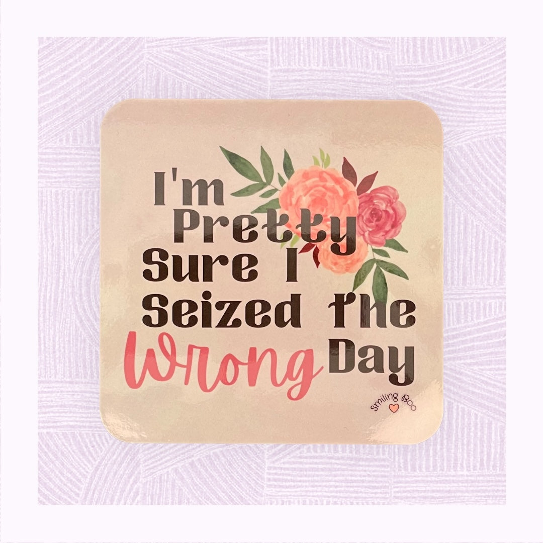 Square coaster with a pastel pink/peach watercolour background with the phrase ‘I’m pretty sure I seized the wrong day’ and floral arrangement