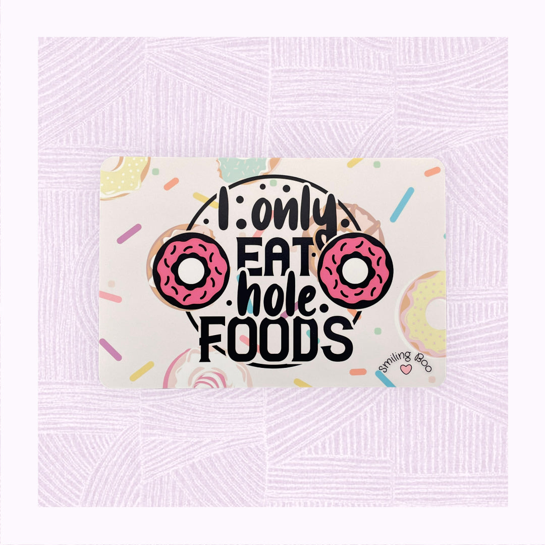 Postcard art print with printed background of raining doughnuts, and the phrase ‘I only eat hole foods’ with a pink doughnut either side.