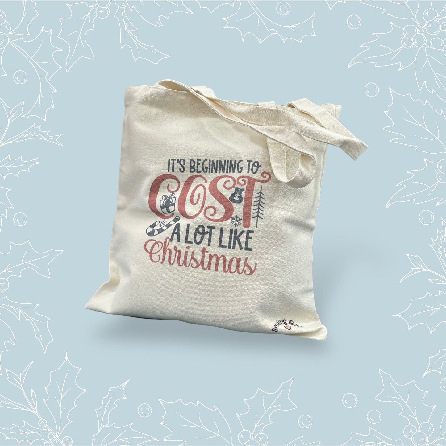 Canvas tote bag with ‘It’s beginning to cost a lot like Christmas’ in black and red with festive embellishments