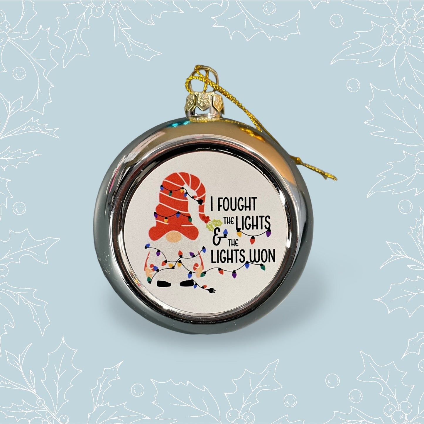 A silver bauble with a Gong tangled in lights with the phrase ‘I fought the lights and the lights won’