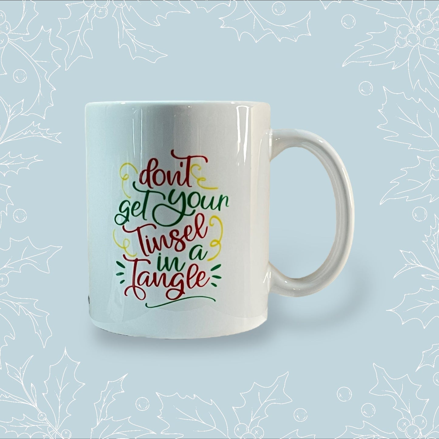 Ceramic mug with ‘Don’t get you tinsel in a tangle’ in festive colours and font
