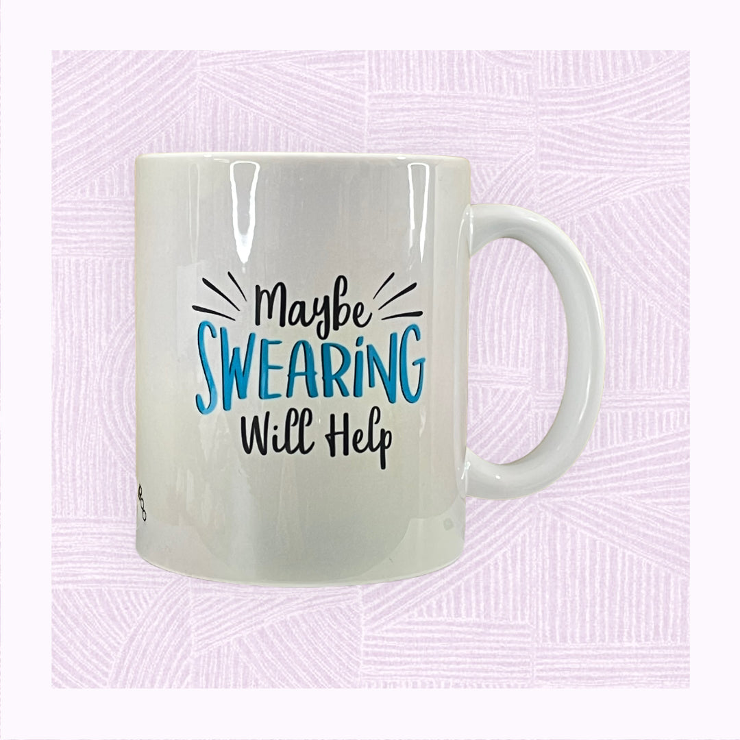 Ceramic mug with a blue pastel background and the phrase ‘Maybe swearing will help’ on it as if exploding off the mug.