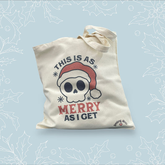 Canvas tote bag with ‘This is as merry as I get’ on it with a skull wearing a Santa hat on