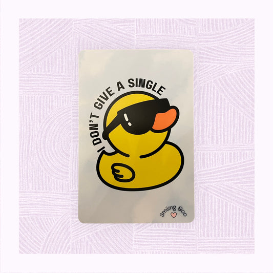 Postcard art print with a blue and white watercolour background and a rubber duck wearing sunglasses, with the phrase ‘I don’t give a single…’