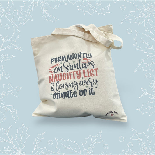 Canvas tote bag with ‘Permanently on Santa’s naughty list and loving every minute of it in black and red embellishments