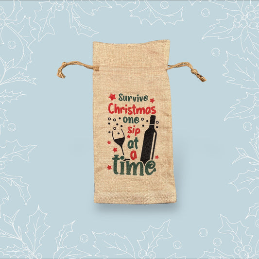 A burlap bottle bag with the phrase ‘Survive Christmas one sip at a time’