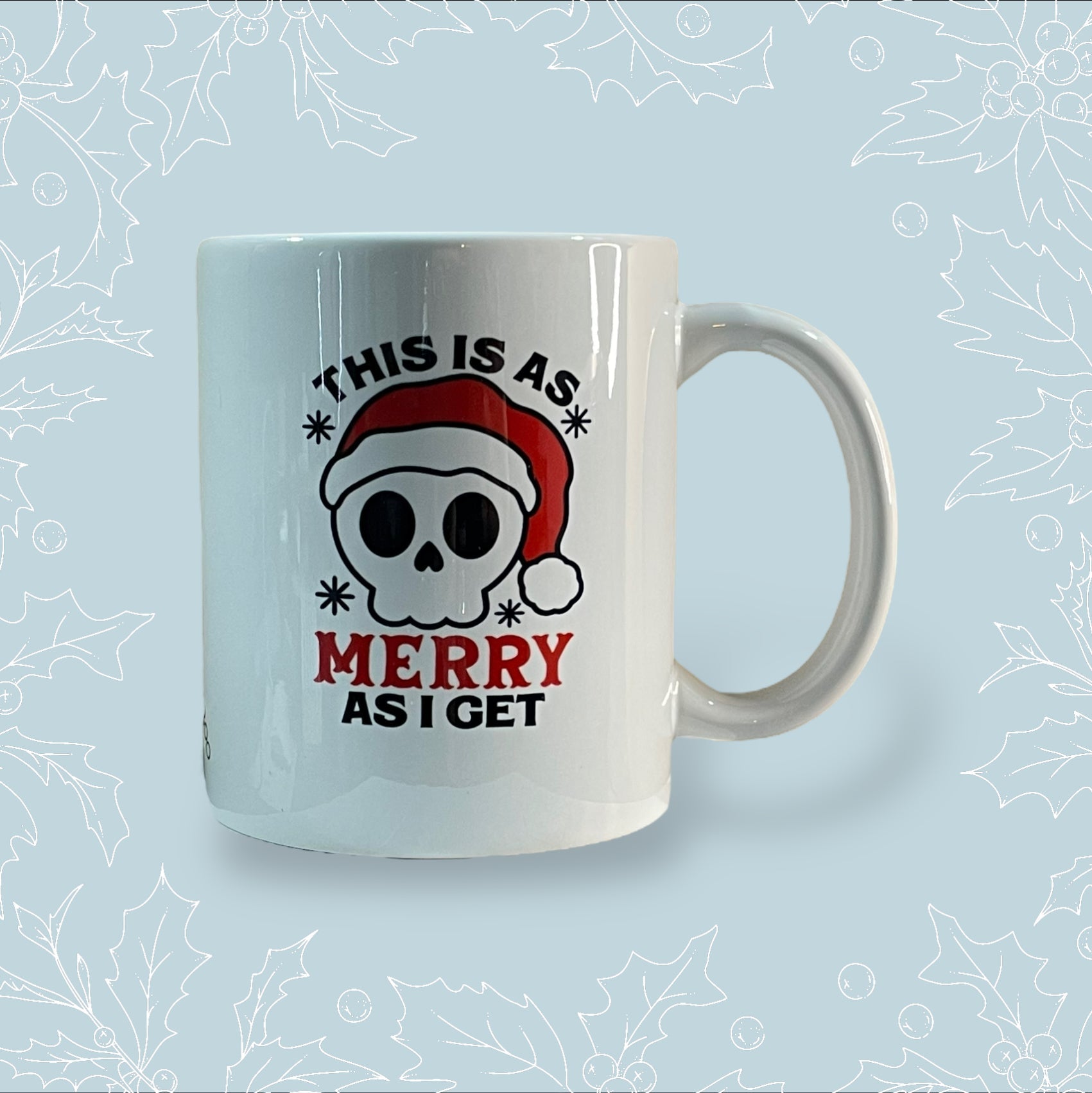Ceramic mug with ‘This is as merry as I get’ on it with a skull wearing a Santa hat on